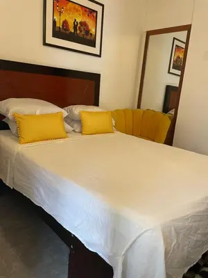 a large white bed with yellow pillows on it at Departamento mejor sector de Ica in Ica