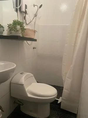 a white bathroom with a toilet and a sink at Departamento mejor sector de Ica in Ica