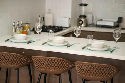 a kitchen counter with plates and wine glasses on it at Well-Located and Modern Apartment in Barranco in Lima