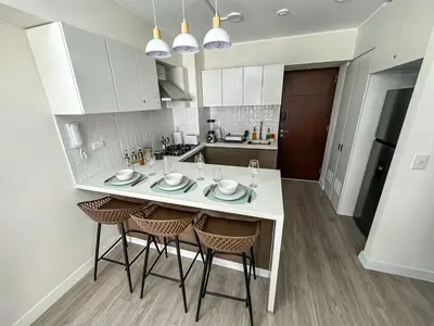 a white kitchen with a table and chairs at Well-Located and Modern Apartment in Barranco in Lima