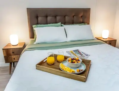 a tray of fruit and drinks on a bed at Well-Located and Modern Apartment in Barranco in Lima