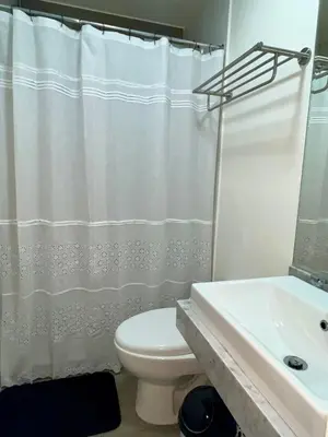 a bathroom with a white toilet and a sink at INTI Studio Apartment in Lima
