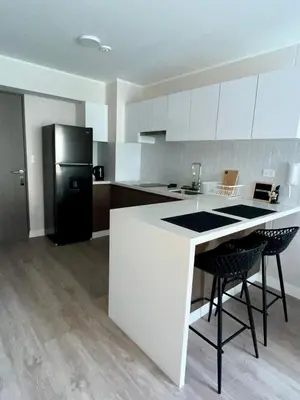 a kitchen with a white counter and a black refrigerator at INTI Studio Apartment in Lima