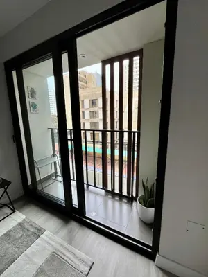 a room with a large glass door with a balcony at INTI Studio Apartment in Lima