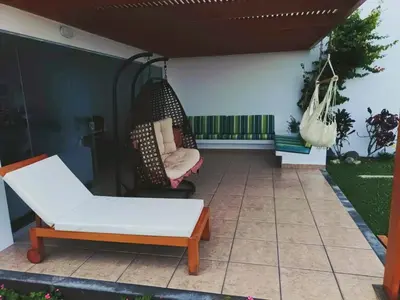 a patio with a swing and a hammock at Espectacular Casa de Playa en Asia frente al Mar in Asia