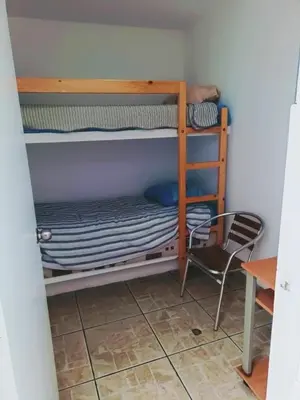 a room with two bunk beds and a chair at Espectacular Casa de Playa en Asia frente al Mar in Asia