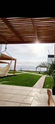 a person laying on a bed in a hammock at Espectacular Casa de Playa en Asia frente al Mar in Asia