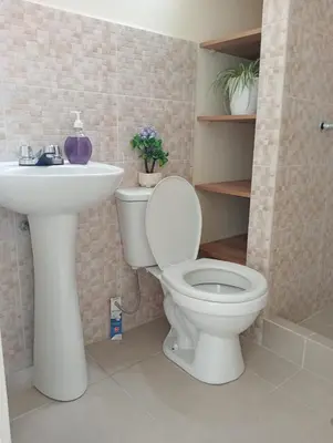 a bathroom with a white toilet and a sink at Alojamiento Casa en Ica in Ica