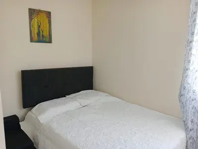 a bedroom with a white bed and a picture on the wall at Alojamiento Casa en Ica in Ica