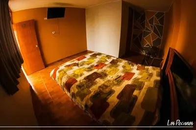 a bedroom with a bed with a colorful quilt on it at Hotel Los Pecanos in Ica