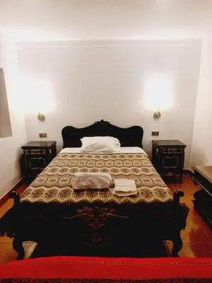 a bedroom with a large bed with two night stands at Casa Conquista in Cusco