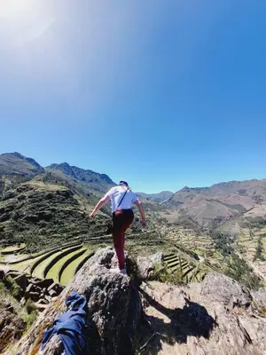 a woman standing on a rock on a mountain at Casa Conquista in Cusco