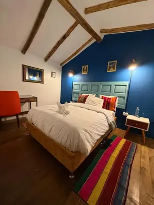 a bedroom with a bed with a cat laying on it at Anido Hotel in Ollantaytambo
