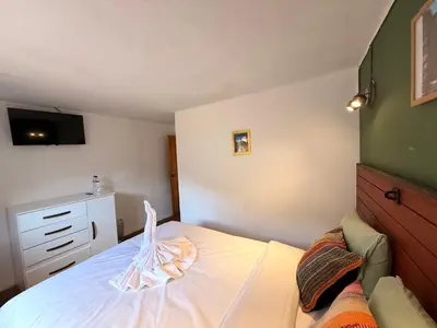 a small bedroom with a bed and a dresser at Anido Hotel in Ollantaytambo