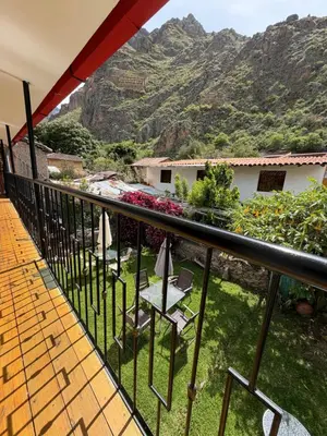 a balcony with chairs and a view of a mountain at Anido Hotel in Ollantaytambo