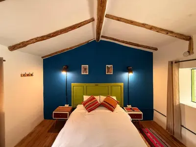 a bed in a room with a blue wall at Anido Hotel in Ollantaytambo
