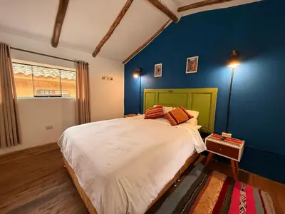 a bedroom with a large bed with blue walls at Anido Hotel in Ollantaytambo