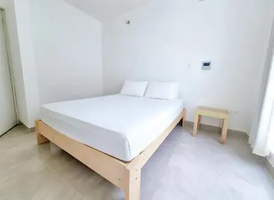 a white bed in a room with a table at Bujama beach Home Family Asia in Mala