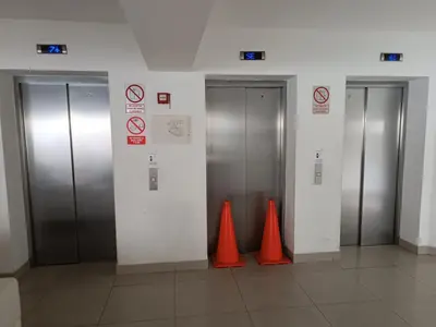 two elevators with orange cones in a building at Departamento con vista al Circuito Mágico del Agua in Lima