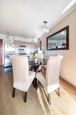 a kitchen and dining room with a table and chairs at Departamento con vista al Circuito Mágico del Agua in Lima