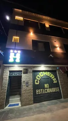 a building with a sign on the front of it at night at Hostal El Bosque in Huánuco