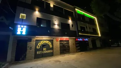 a building with a sign on the side of it at night at Hostal El Bosque in Huánuco