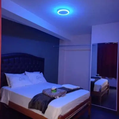 a bedroom with a large bed with a blue ceiling at Hostal El Bosque in Huánuco