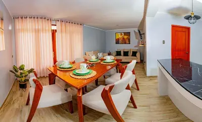 a dining room with a wooden table and chairs at La covacha de viejo in Jauja