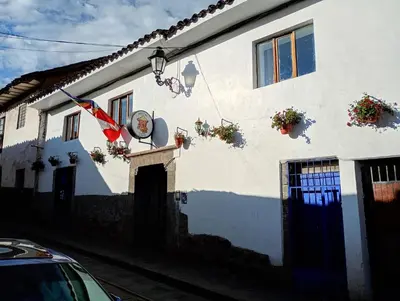 a white house with a flag on the side of it at La casa de Goya in Cusco