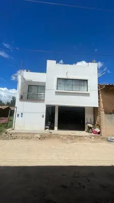 a white building with two garage doors on a street at Malka Casas - Hoteles in Marco