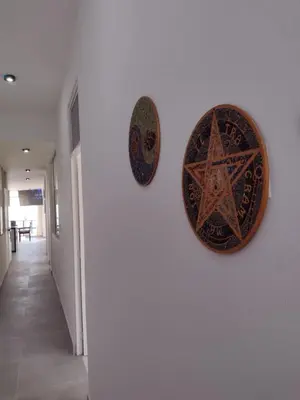 two plates hanging on a wall in a hallway at Macky'sThe Silence in Bombiso