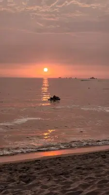 a sunset on the beach with the sun setting at Macky'sThe Silence in Bombiso