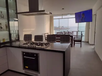 a kitchen with a stove top oven next to a living room at Macky'sThe Silence in Bombiso