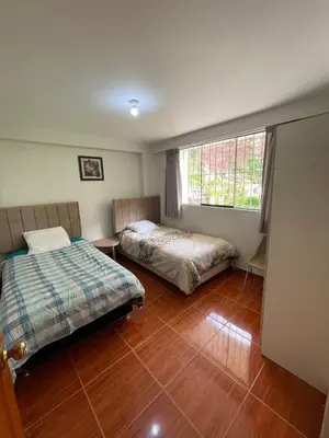 a bedroom with two beds and a window at La esquina de vallecito in Cusco