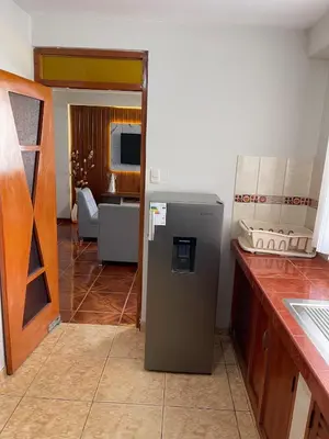 a kitchen with a refrigerator in the middle of a room at La esquina de vallecito in Cusco