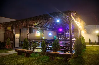 a building with two benches in front of it at night at Hotel Kendari - Chincha in Chincha