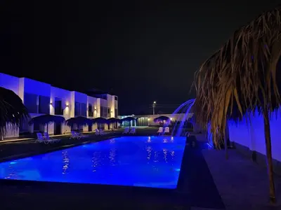 a swimming pool at night with blue lights at Hotel Kendari - Chincha in Chincha