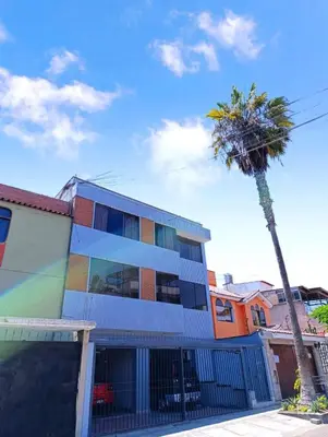 a colorful building with a palm tree in front of it at La Palmera in Lima
