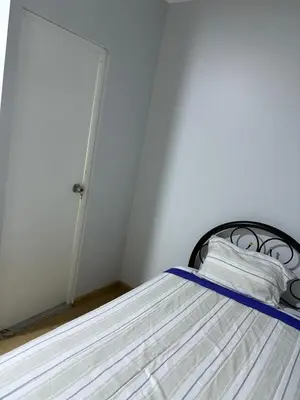 a bedroom with a bed with white sheets and a door at Villa MAS - Condominio Hacienda II in Pachacamac