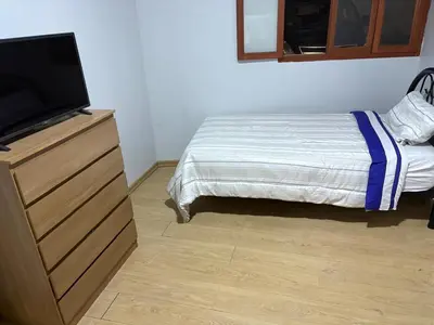 a bedroom with a bed and a dresser with a flat screen tv at Villa MAS - Condominio Hacienda II in Pachacamac
