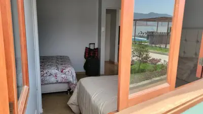 a room with a bed and a view of the ocean at Villa MAS - Condominio Hacienda II in Pachacamac