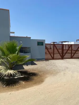 a palm tree in front of a building with a gate at Linda Casa en Condominio in Asia