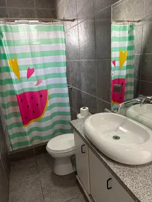 a bathroom with a shower curtain with a slice of watermelon at Linda Casa en Condominio in Asia
