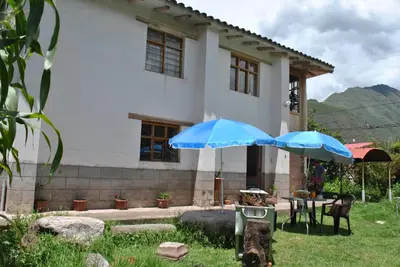 two blue umbrellas in front of a house at Pisonaywasi - Hospedaje familiar in Urubamba