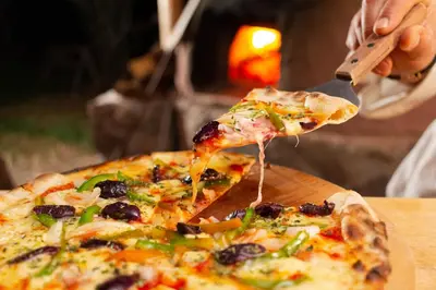 a person eating a slice of pizza with a spatula at Casa de La Chola in Ollantaytambo