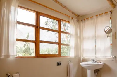a bathroom with a sink and a toilet and a window at Casa de La Chola in Ollantaytambo