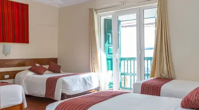 a hotel room with two beds and a balcony at La Casona Real Cusco in Cusco