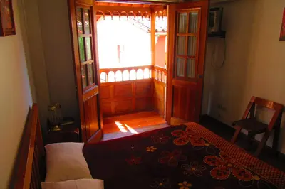a bedroom with a bed and a large window at Hospedaje Kamila in Cusco