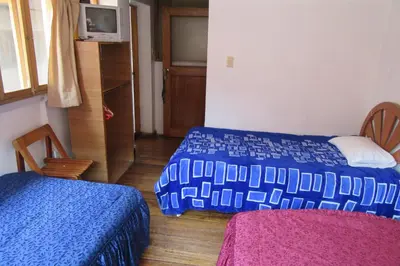 a bedroom with two beds and a tv in it at Hospedaje Kamila in Cusco