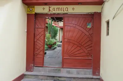 an entrance to a red gate in a street at Hospedaje Kamila in Cusco